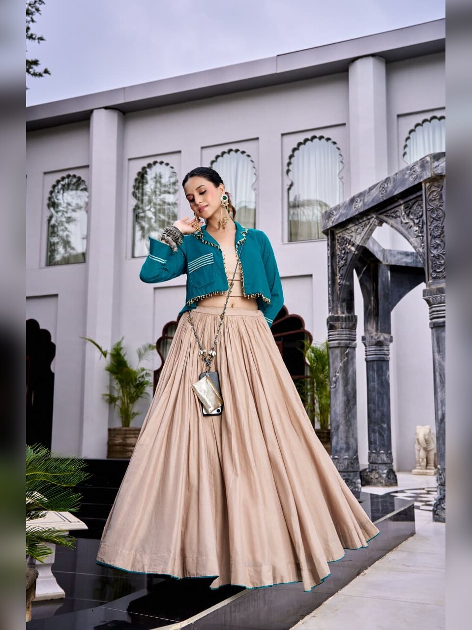 Side view of the beige Chhabili skirt with the teal jacket and beaded edging