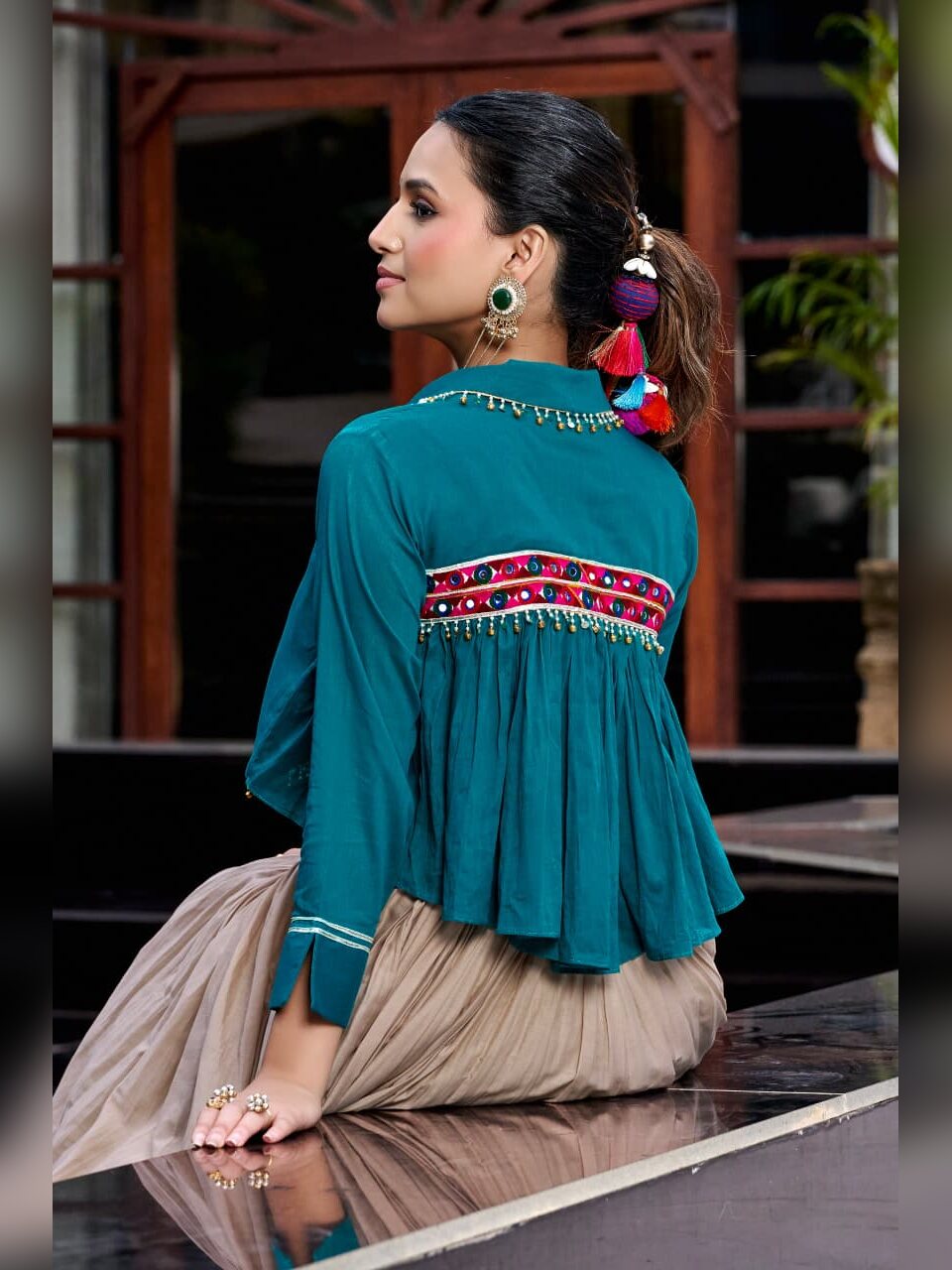 Back view of the teal jacket showing the mirror work band