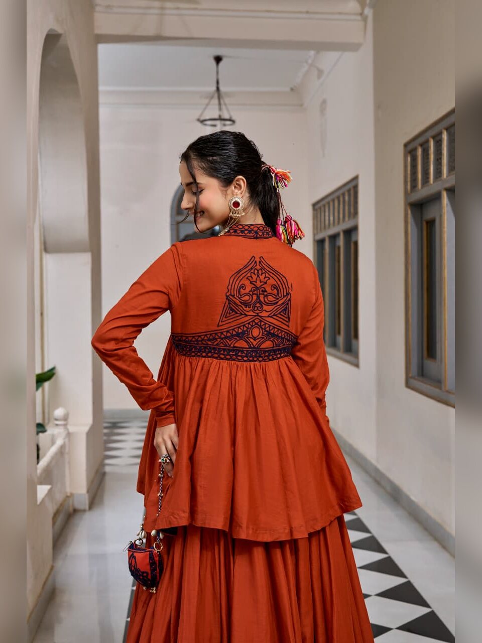 Back view of the rust Chhabili peplum top with navy Kashida embroidery